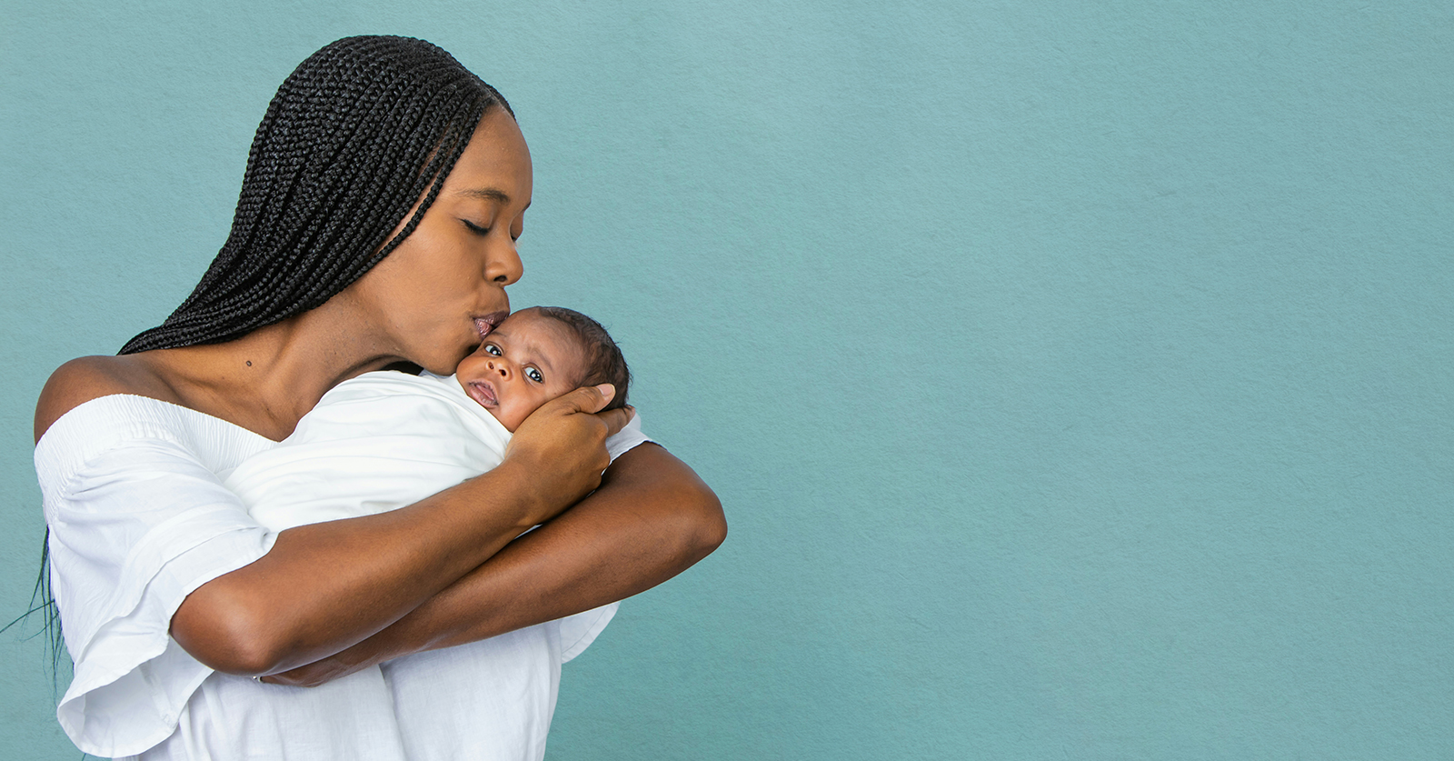 mom kissing infant